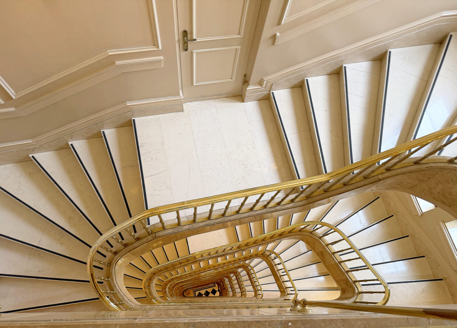 Spiral marble staircase with gold railing