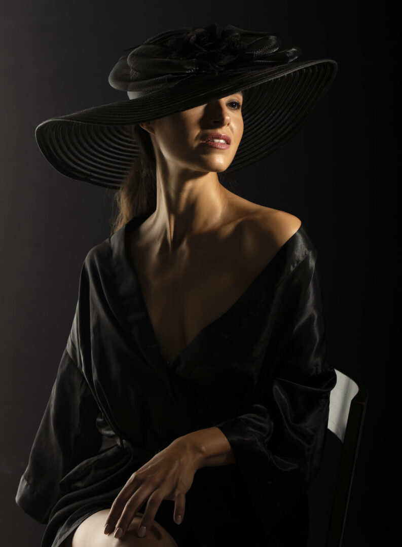 Woman in wide-brim black hat and dress